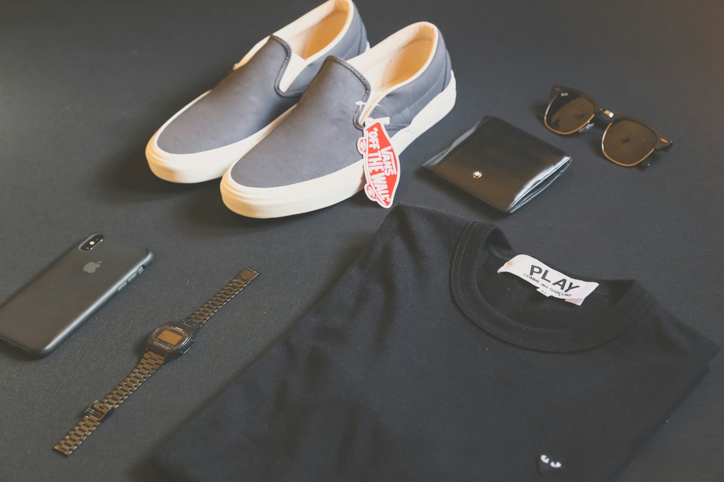 Flat lay of black clothing and accessories arranged diagonally.